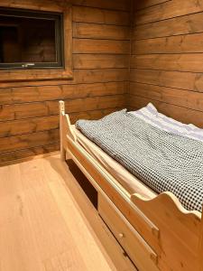 a bedroom with a bed in a wooden cabin at Architect-Designed Log Cabin By Myllavannet in Lunner