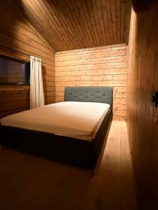 a bedroom with a bed in a wooden room at Architect-Designed Log Cabin By Myllavannet in Lunner