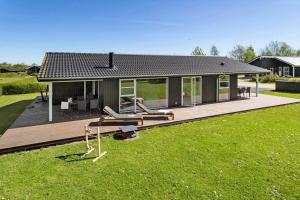 a house with a wooden deck with a backyard at 30451-Odder-Strandvaenget-7 in Odder