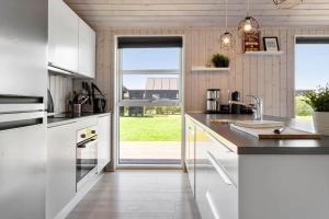 a kitchen with white cabinets and a large window at 30451-Odder-Strandvaenget-7 in Odder