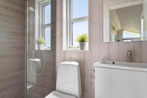 a bathroom with a toilet and a sink and a mirror at 30451-Odder-Strandvaenget-7 in Odder +17 photos