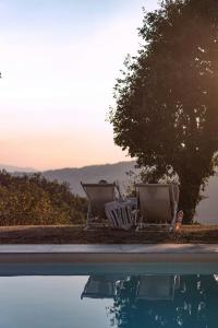 two chairs sitting next to a swimming pool at Mountain Farmhouse Between Parma And Cinque Terre in Solignano