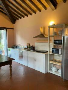 a large kitchen with white cabinets and a table at Mountain Farmhouse Between Parma And Cinque Terre in Solignano
