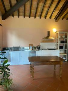 a large kitchen with white cabinets and a wooden table at Mountain Farmhouse Between Parma And Cinque Terre in Solignano