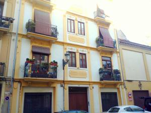 un edificio amarillo con balcones y plantas. en Quart Silence, en Valencia