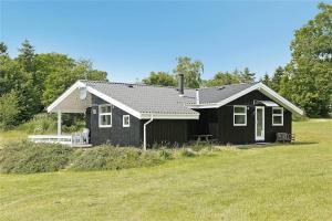 a black house sitting on top of a field at 30727-Odder-Alrovej-203-A in Odder