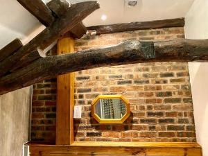 a brick wall with a yellow window on it at Rebecca Puddle Duck Cottage in Bassenthwaite