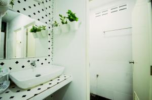 a white bathroom with a sink and a mirror at Early Bird Hostel Ayutthaya in Phra Nakhon Si Ayutthaya
