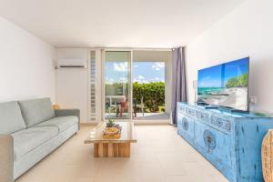 a living room with a couch and a tv at Lounge modern chill studio Orient Bay in Orient Bay