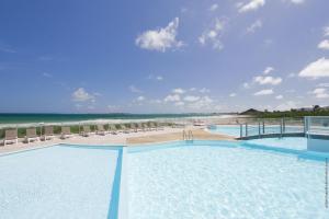 a resort with two pools and a beach at Lounge modern chill studio Orient Bay in Orient Bay