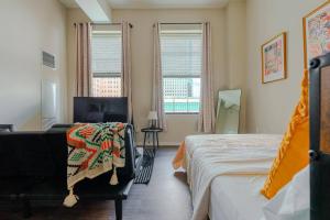 a bedroom with two beds and a chair and windows at The City Escape| Studio Apt w/ Skyline Views in Cincinnati +69 photos