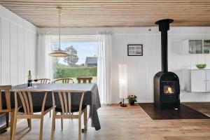 a dining room with a table and a stove in a room at 30457-Odder-Snekkeager-20 in Odder