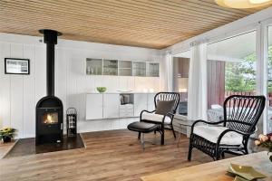a living room with a fireplace and a table and chairs at 30457-Odder-Snekkeager-20 in Odder +22 photos