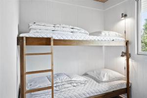two bunk beds in a room with a ladder at 30457-Odder-Snekkeager-20 in Odder