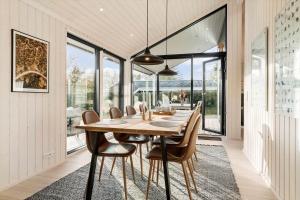 a dining room with a wooden table and chairs at 30319-Odder-Grindevej-19 in Odder