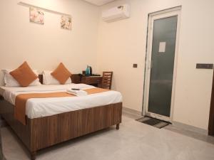 a bedroom with a bed and a sliding glass door at Life Tree Hotel and Banquet Hall, Sector 63A in Noida