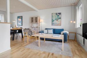 a living room with a blue couch and a table at 40168-Juelsminde-Strandengen-52 in Juelsminde