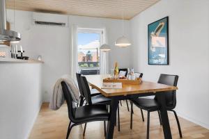 a dining room with a wooden table and black chairs at 40168-Juelsminde-Strandengen-52 in Juelsminde