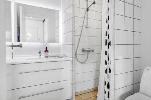 a white bathroom with a shower and a sink at 40168-Juelsminde-Strandengen-52 in Juelsminde +22 photos