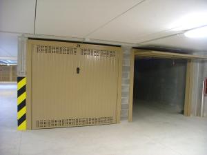 a large garage door in a parking lot at Costa Azzurra Apartment in Grado