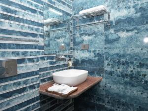 a bathroom with a sink and a blue tiled wall at Life Tree Hotel and Banquet Hall, Sector 63A in Noida +62 photos
