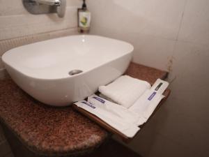 a bathroom with a white sink and towels on a counter at Life Tree Hotel and Banquet Hall, Sector 63A in Noida