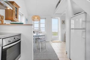 a white kitchen with a table and a refrigerator at 40155-Juelsminde-Bugten-31 in Juelsminde +23 photos