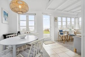 a living room with a white table and chairs at 40155-Juelsminde-Bugten-31 in Juelsminde