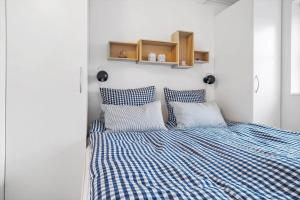 a bedroom with a bed with blue and white sheets at 40155-Juelsminde-Bugten-31 in Juelsminde
