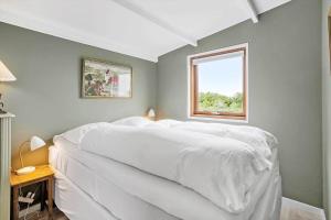 a bedroom with a large white bed with a window at 30725-Odder-Skovgardsparken-87 in Odder