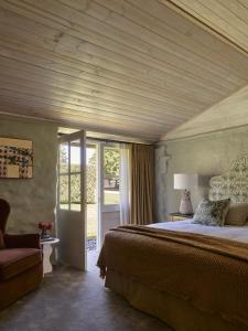 a bedroom with a large bed with a wooden ceiling at Bendooley Estate in Berrima