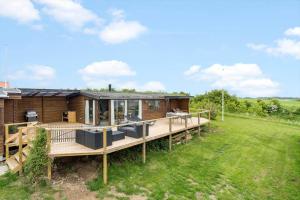 a wooden house with a deck and a yard at 30725-Odder-Skovgardsparken-87 in Odder