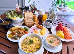 a wooden table with plates of food on it at Silom Serene A Boutique Hotel in Bangkok