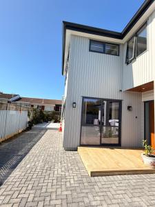 a house with a wooden deck in front of it at Modern Private 2BR Unit in Takapuna in Auckland