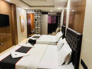 a row of beds in a hotel room at Hotel U Life Residency Mumbai in Mumbai