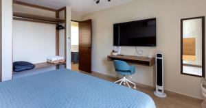 a bedroom with a bed and a desk and a tv at Casa Venado in Caucel