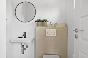 a bathroom with a sink and a toilet and a mirror at 30465-Odder-Stakket-Torn-9 in Odder +25 photos