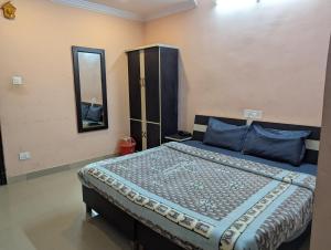 a bedroom with a bed with blue pillows and a mirror at Silver oak Hotel and Restaurant in Pāndoh