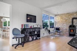 a living room with a chair and a fireplace at 30355-Odder-Granvej-14 in Odder