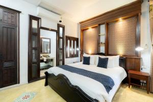 a bedroom with a large bed and a bathroom at Cheva Gallery Boutique Hotel in Chiang Mai