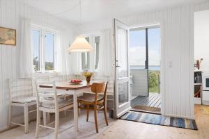a white dining room with a table and chairs at 40161-Juelsminde-Bugten-30 in Juelsminde