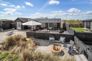 a house with a patio with a table and an umbrella at 30594-Odder-Toldvejen-45-H in Odder
