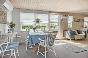 a kitchen and living room with a table and chairs at 40159-Juelsminde-Mirabellevej-1 in Juelsminde