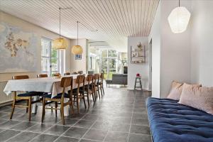 a dining room with a table and chairs and a couch at 40117-juelsminde-Gludvej-7 in Juelsminde