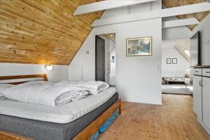 a large bed in a room with a wooden ceiling at 40117-juelsminde-Gludvej-7 in Juelsminde