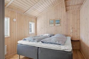 a bedroom with a bed in a room with wooden walls at 40146-Juelsminde-Elmealle-24 in Juelsminde