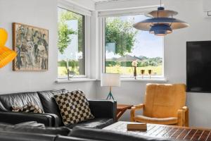 a living room with a black couch and a chair at 30609-Odder-Spovevej-1 in Odder