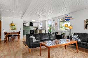 a living room with a black couch and a table at 30609-Odder-Spovevej-1 in Odder