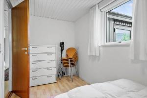 a bedroom with a bed and a dresser and a window at 30609-Odder-Spovevej-1 in Odder