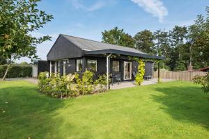 a small black house with a grass yard at 30609-Odder-Spovevej-1 in Odder